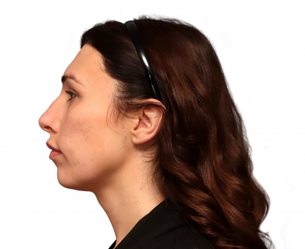 Profile view of a woman with wavy brown hair and a black headband, facing left.