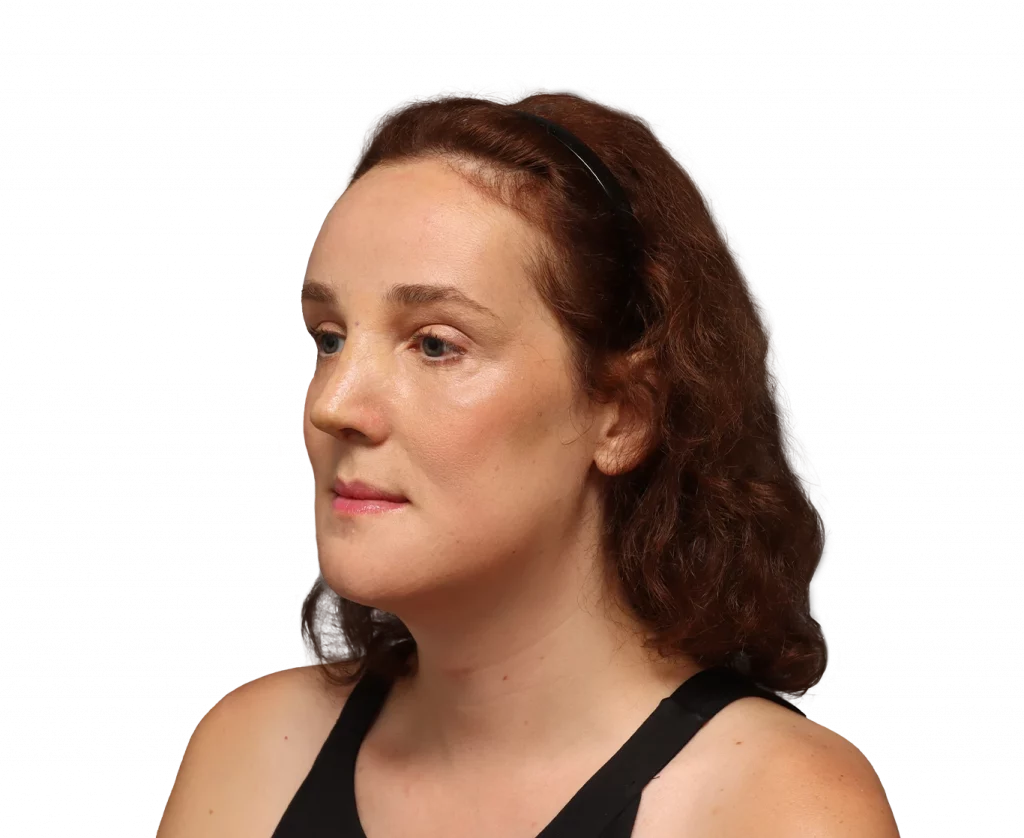 Profile portrait of a woman with brown, wavy hair wearing a black sleeveless top, sunglasses on her head, looking left.
