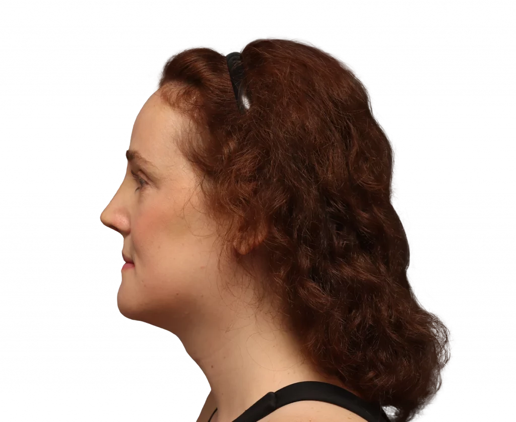 Profile view of a woman with curly auburn hair wearing sunglasses on her head, facing left.