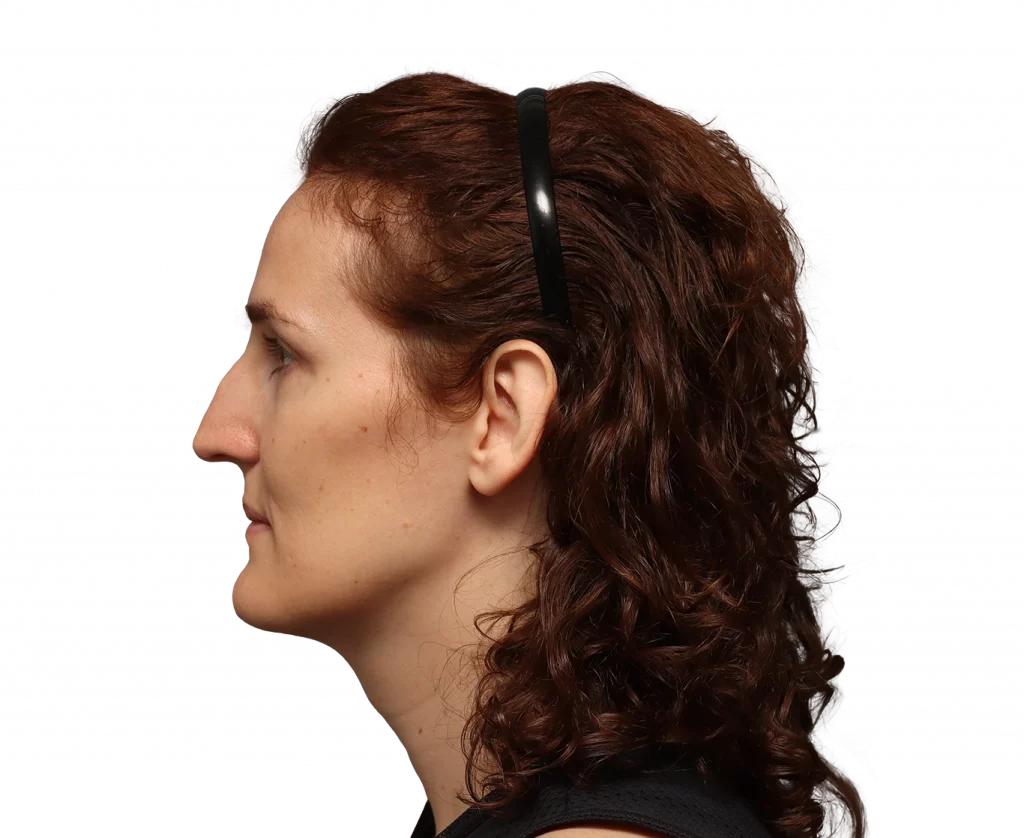 Profile view of a woman with brown wavy hair wearing a black headband, facing left.