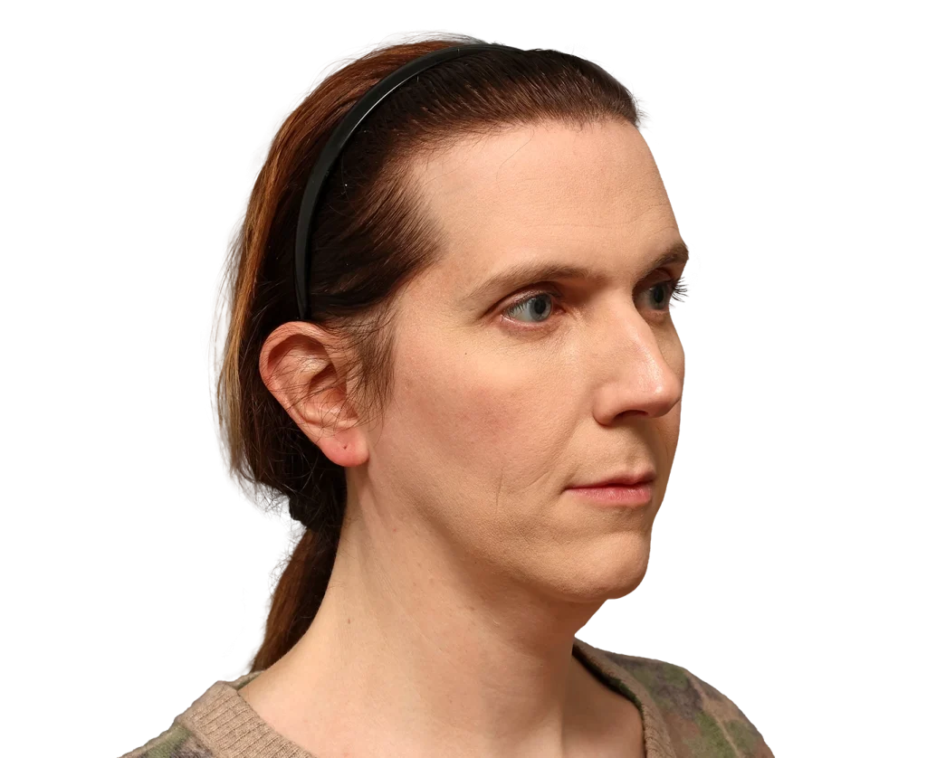 Side-profile portrait of a woman with light skin and brown hair wearing a black headband, looking to the right.