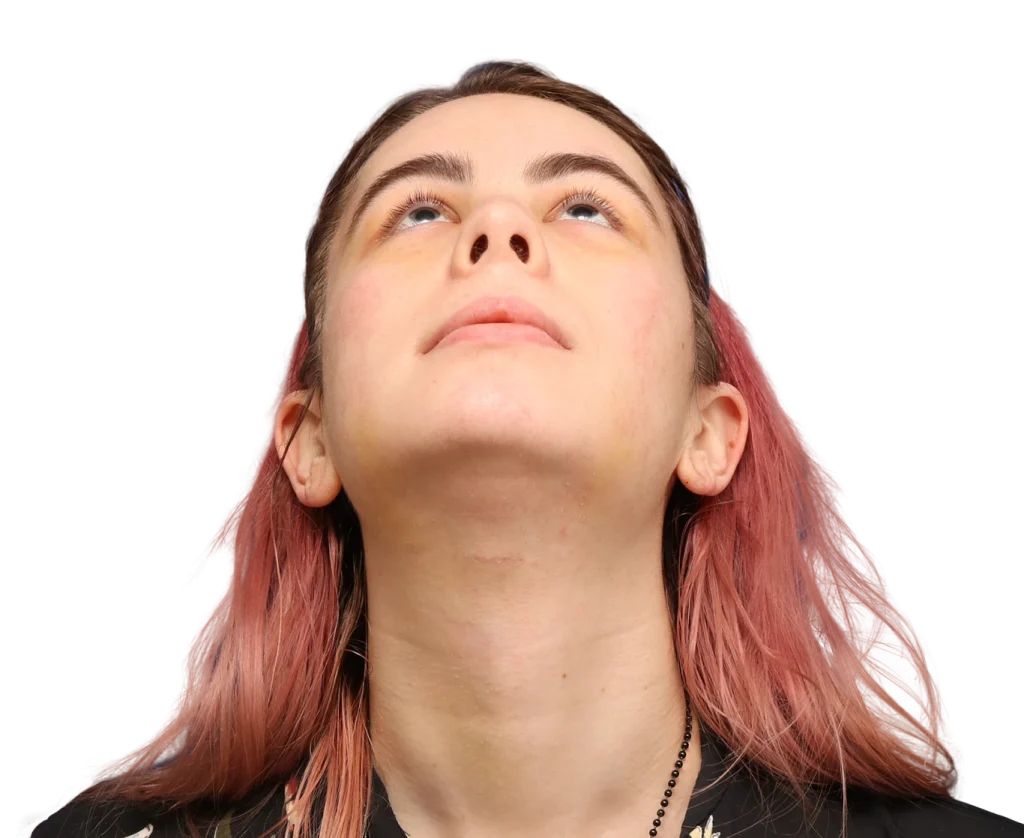 Person tilting head back and looking upward, with pinkish hair visible on the sides.